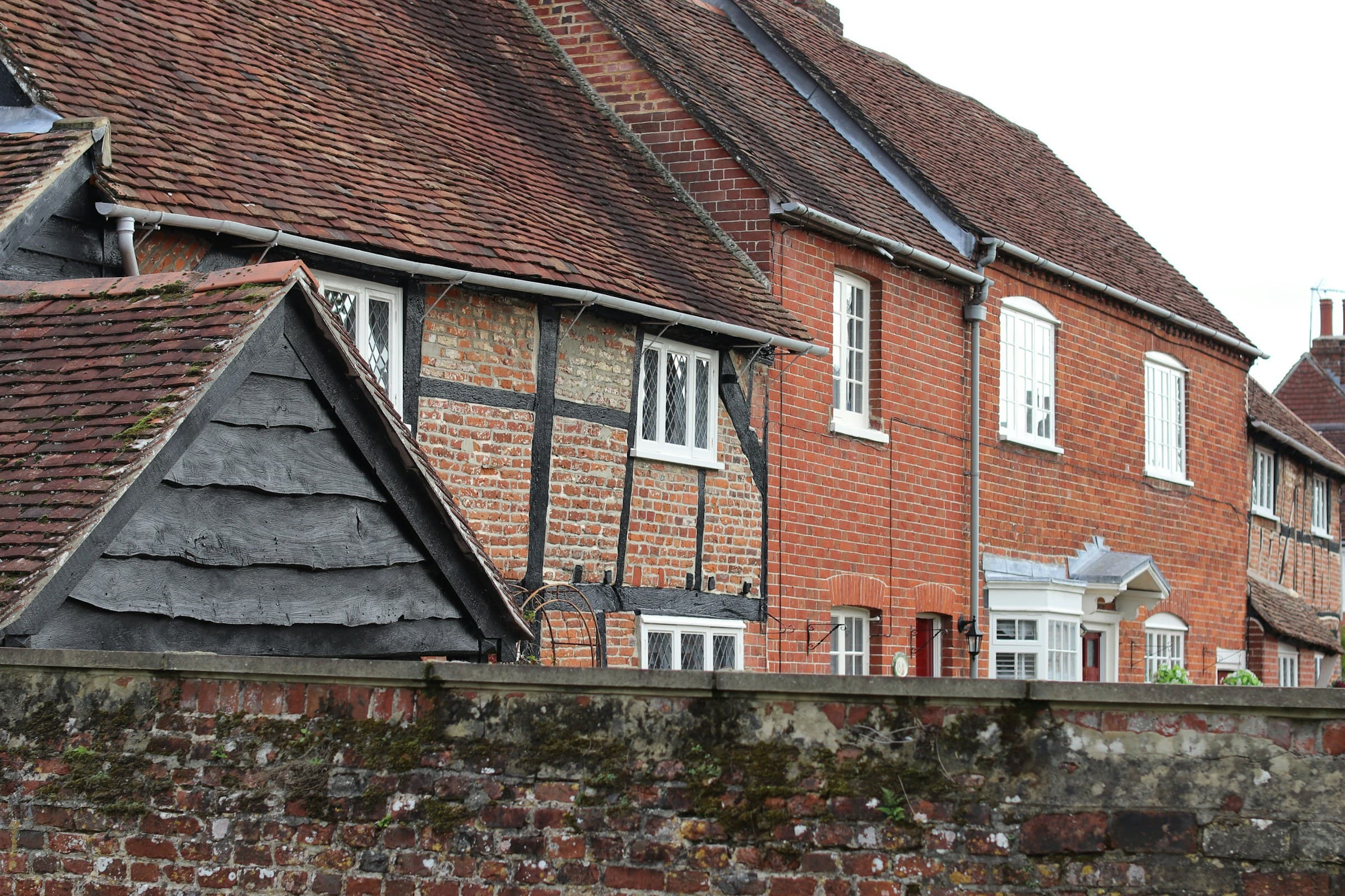 Old brick-and-timber buildings with weathered red tile roofs, their industrial brick elevations aged by long exposure to urban weather.